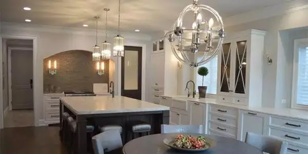 Modern, warm recessed lighting illuminating a freshly renovated home kitchen island, showcasing completed residential electrical services.